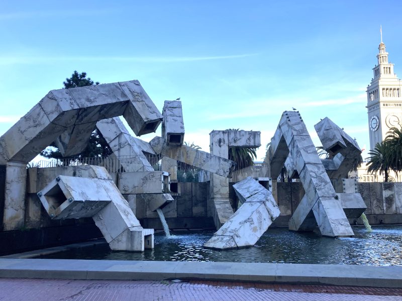 A twisty-shaped fountain at a plaza.