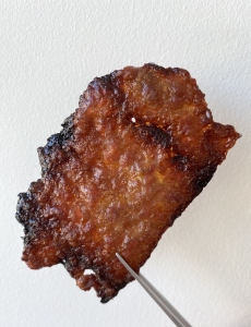 A piece of meat being held up by a fork.