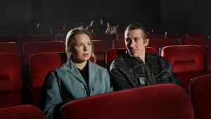 A man and woman sitting in a movie theater.