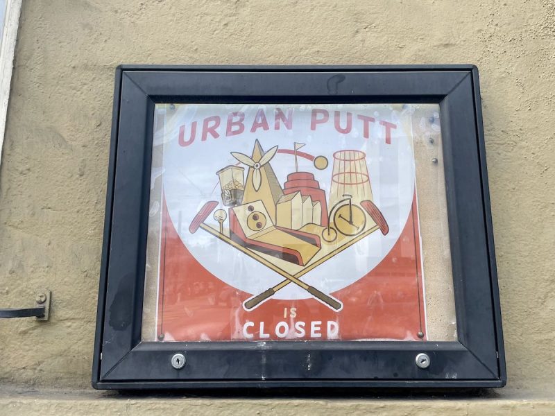 A sign that says Urban Putt on the side of a building.