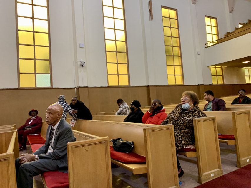 A group of people sitting in pews in a church.