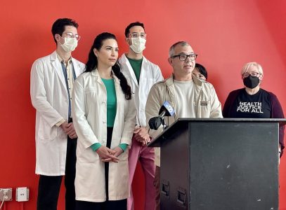 A group of people standing at a podium with masks on.