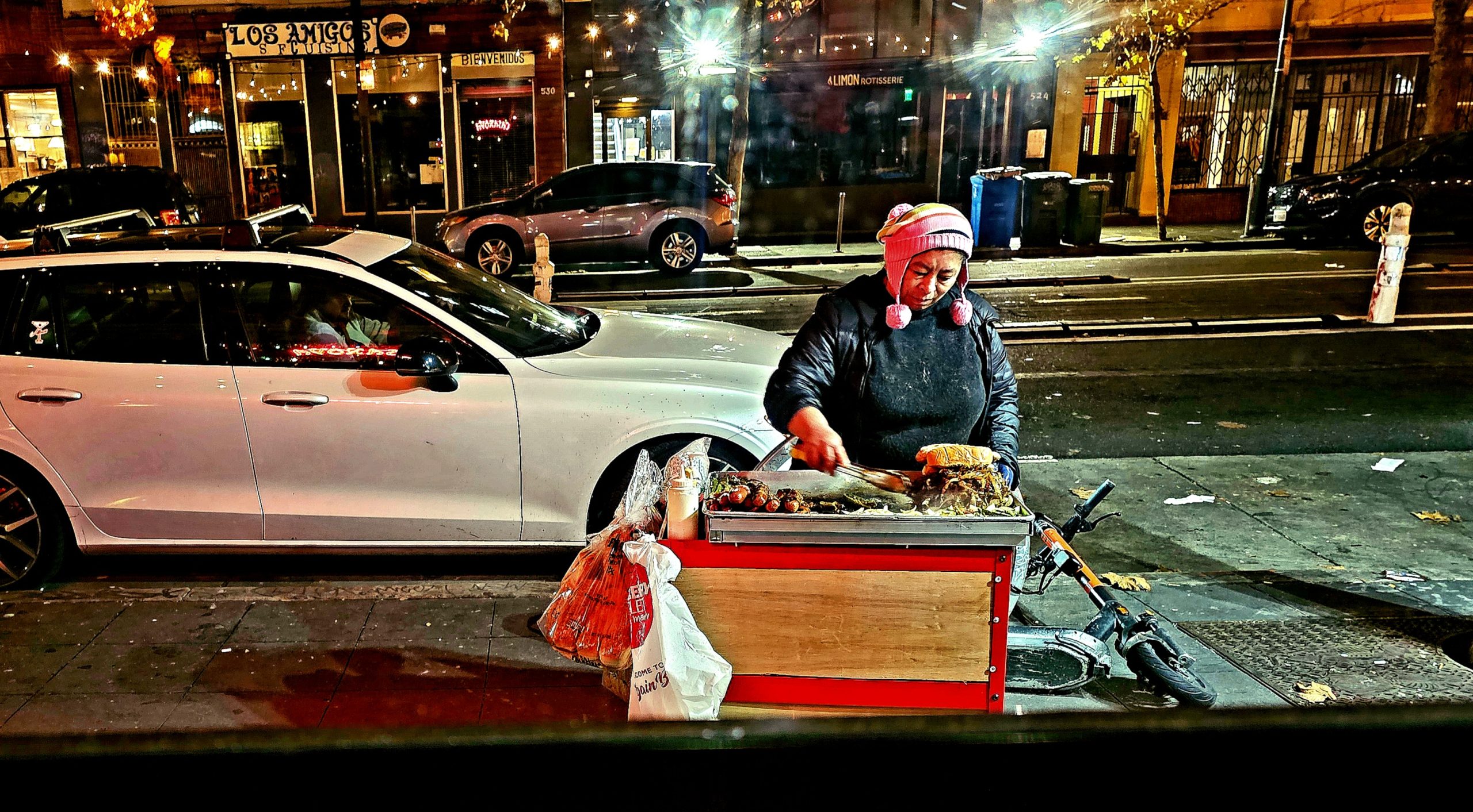 A woman is selling food on the side of the street.