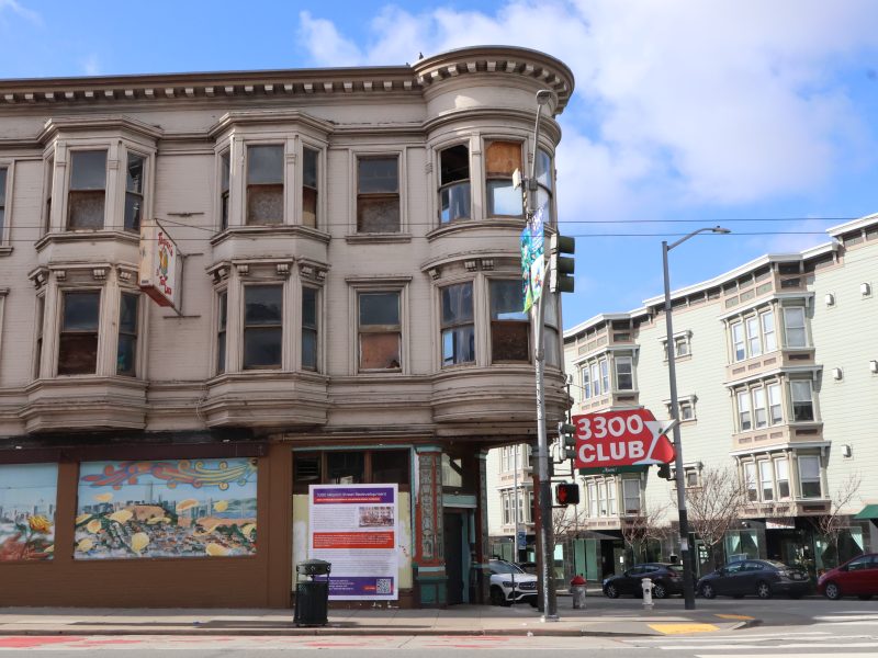 A building with a corner and a sign on the corner.