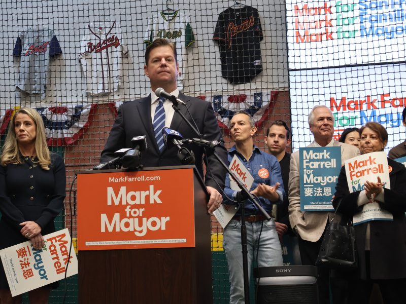 A group of people standing at a podium holding signs.