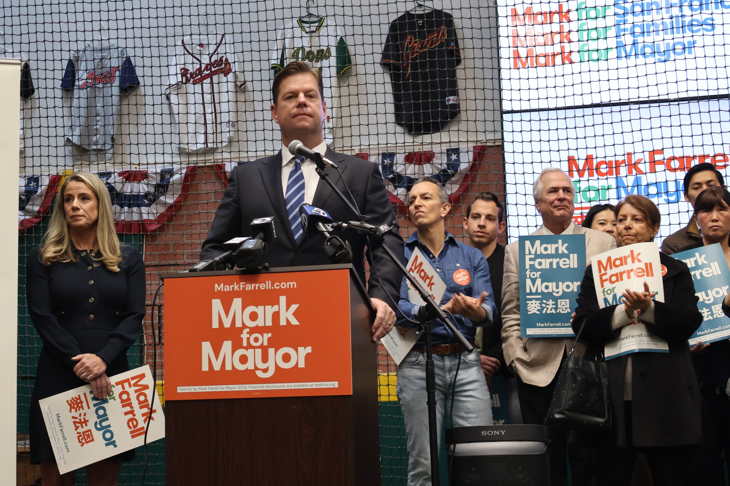 A group of people standing at a podium holding signs.