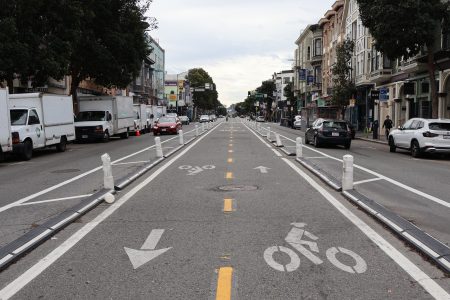 A road with white lines and arrows on it.