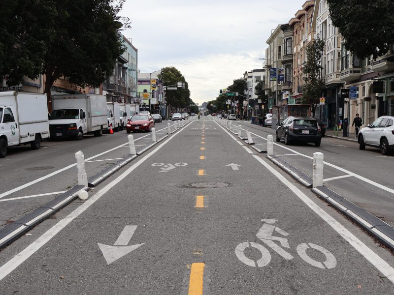 A road with white lines and arrows on it.