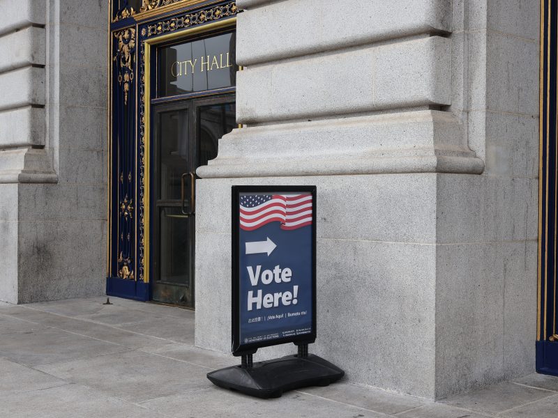 A vote here sign in front of a building.