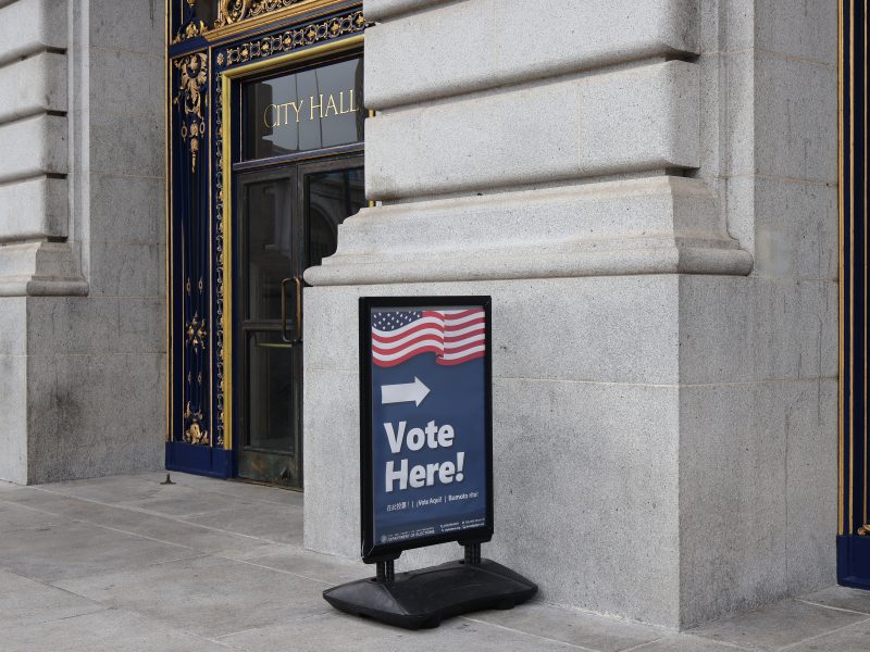 A vote here sign in front of a building.