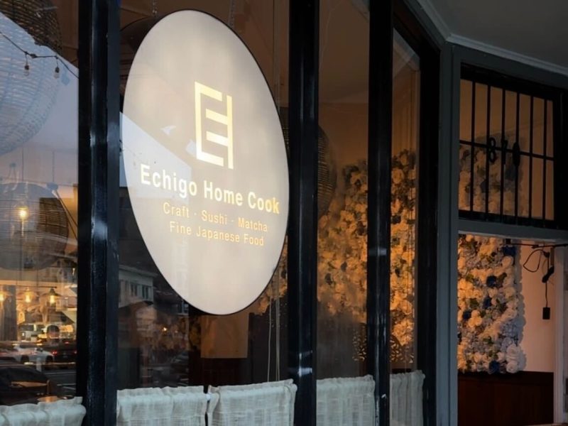 A sign for Echigo Home Cook displayed on a window.