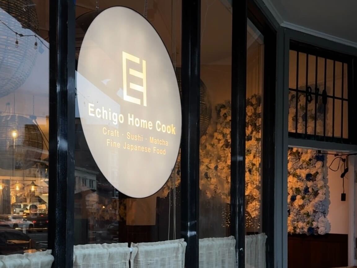 A sign for Echigo Home Cook displayed on a window.