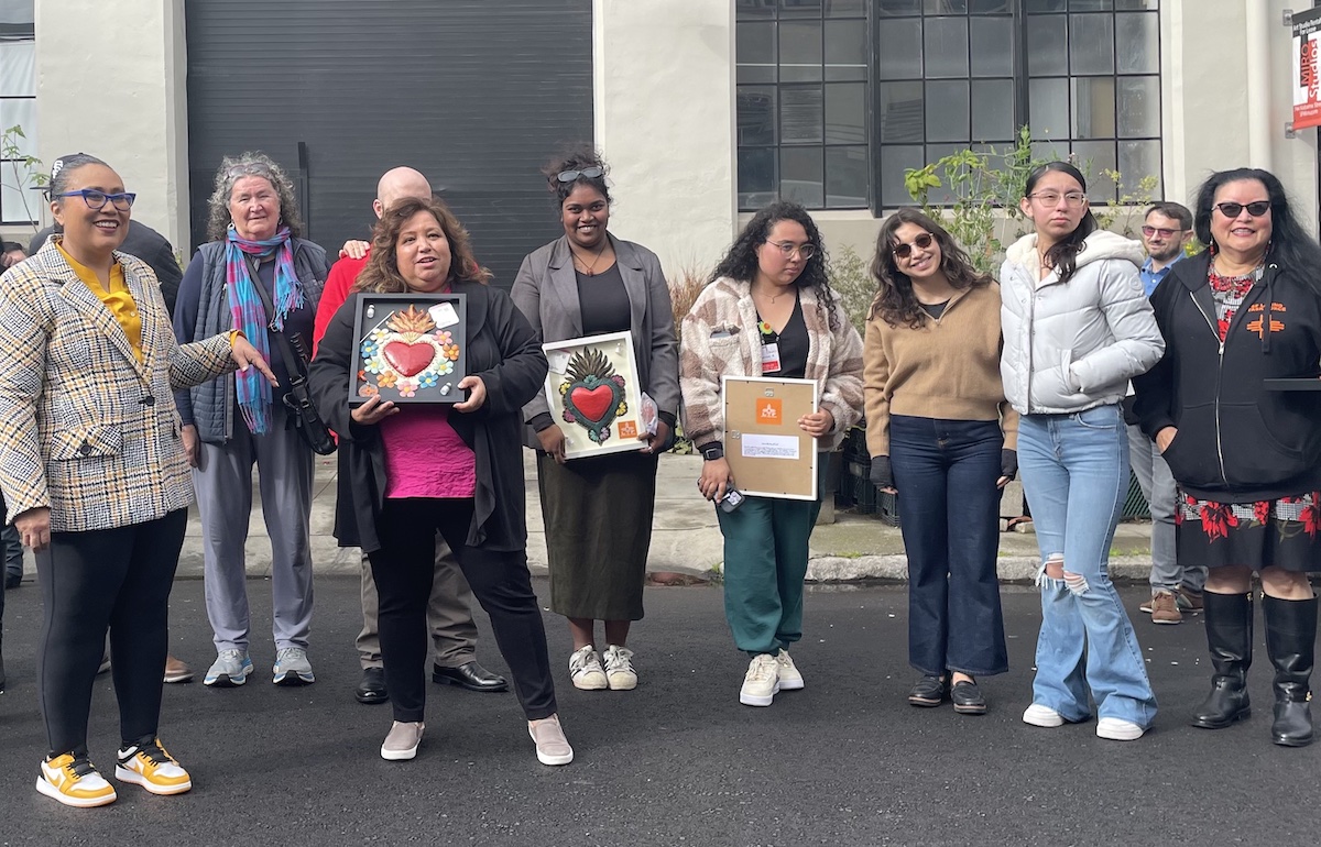 A group of women holding artworks.