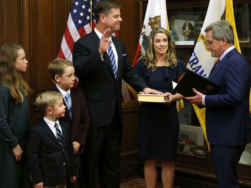 A group of people standing in front of an american flag.
