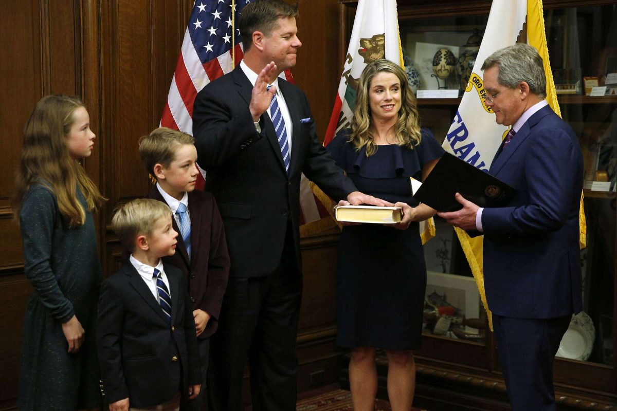 A group of people standing in front of an american flag.