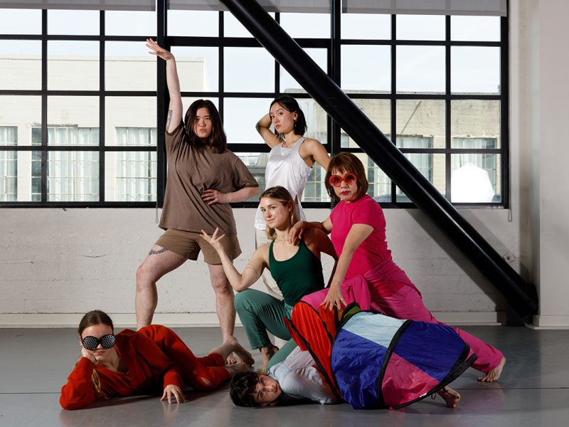 Dancers from ODC dance posing in front of a large window.