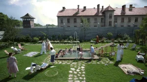 A group of people in a yard with a pool.