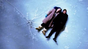 Two people standing on top of a frozen surface.