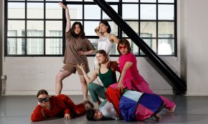 A group of people posing in front of a large window.