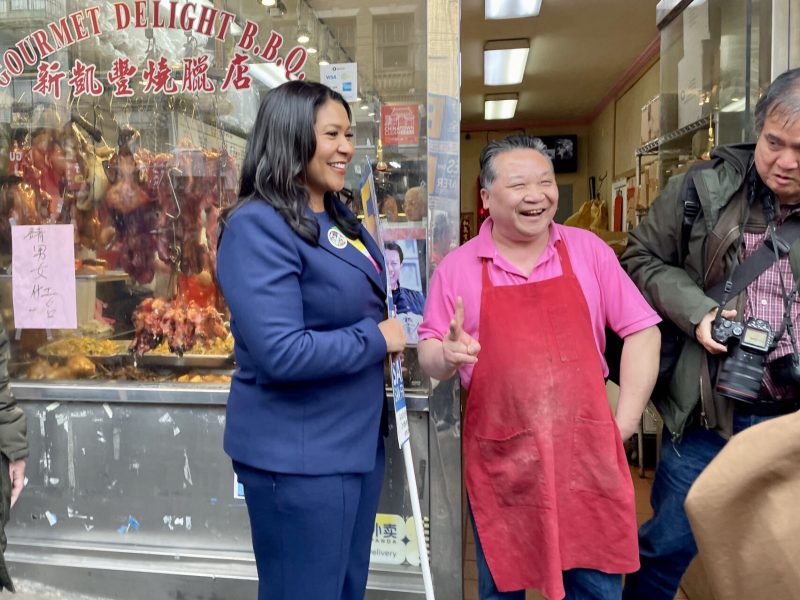 Mayor London Breed standing next to a shopowner in Chinatown, shaking hands