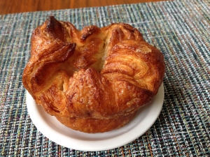 A golden-brown pastry served on a small white plate.