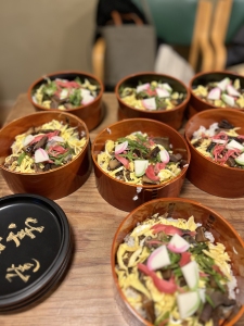 Five bowls of food on a wooden table.