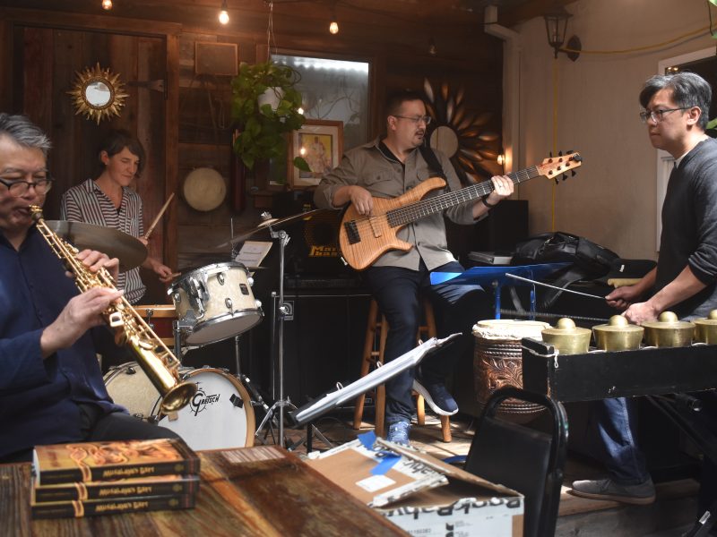 A live jazz quartet performing in a cozy venue with listeners enjoying the music.