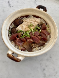 A bowl of rice and meat in a white bowl.
