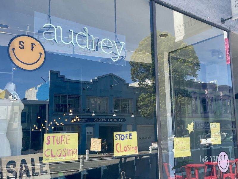 Audrey storefront window with "store closing" signs and reflections.