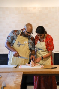 A man and woman preparing food in a kitchen.