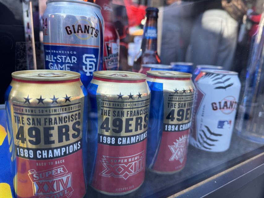 Collection of vintage san francisco 49ers and giants beverage cans displayed on a shelf.