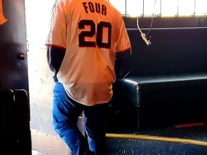 A man wearing a shirt that says "FOUR 20", exiting through the door.