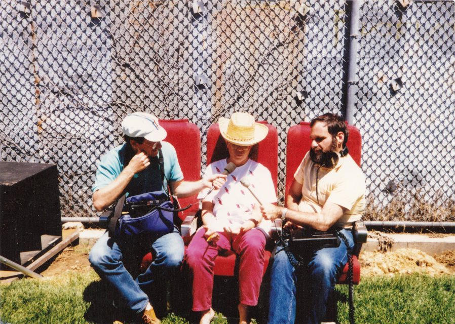 Two journalists interviewing Joan Holden at the backyard of the Mime Troupe's office. Photo courtesy of the Holden-Chumley family.
