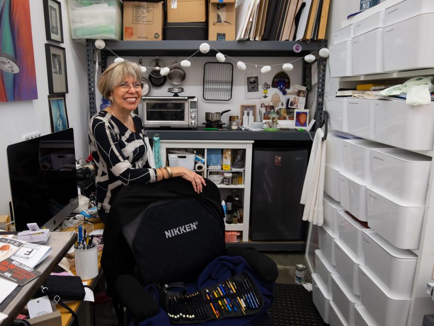 Senior woman smiling in a kitchenette in her art studio
