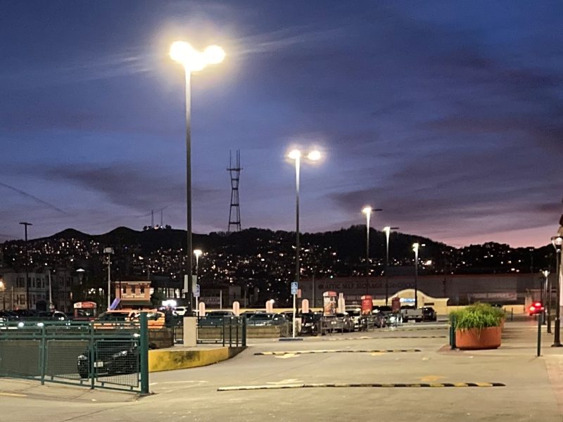 A parking lot at night with lights on.