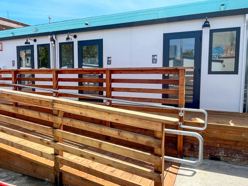 Wooden ramps in front of the accessible white cabins.