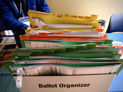 A ballot organizer box filled with various labeled files in multiple colors, designed to organize election documents.