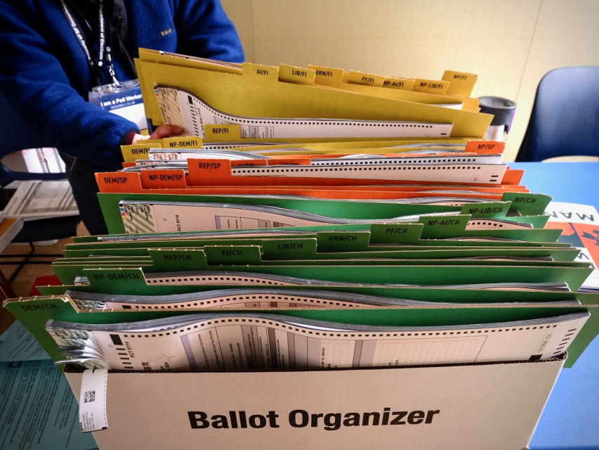 A ballot organizer box filled with various labeled files in multiple colors, designed to organize election documents.