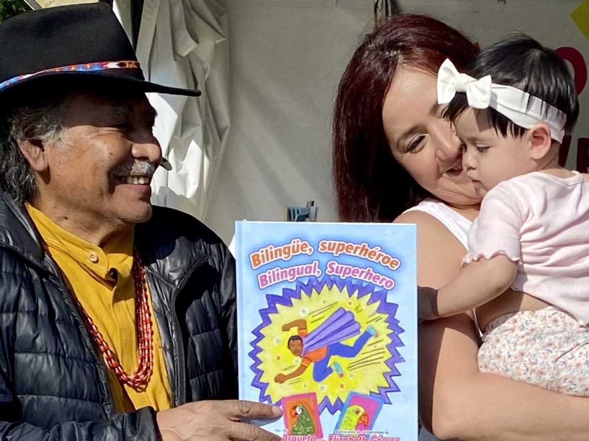 Poet Laureate Jorge Argueta gifts a child his new book Bilingual Superhero