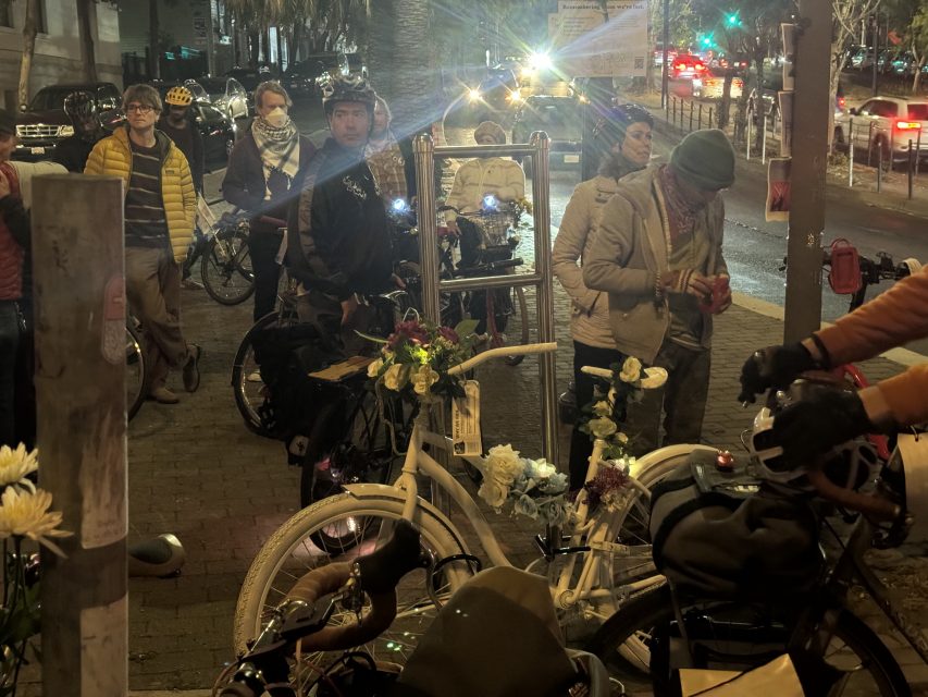 Attendees at the intersection of Octavia and Market streets decorate the ghost bike at the site on Wednesday May 15, 2024. Photo by Oscar Palma.