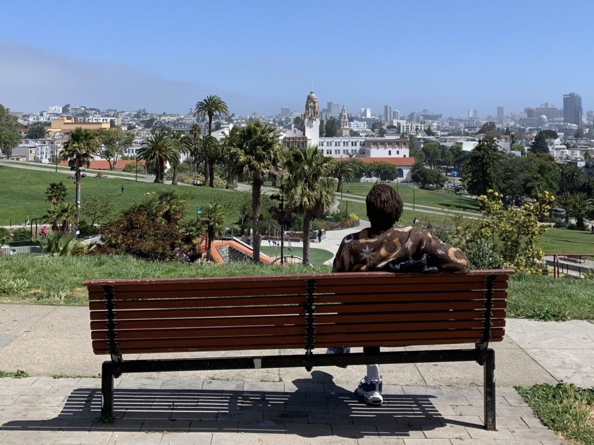 A person sits on a bench at Dolores Park