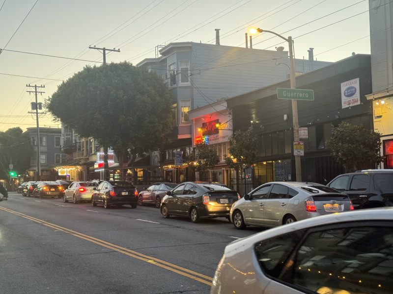 A line of double parked cars on the north side of 16th Street extends all the way from Guerrero to Albion. The situation has gotten the attention from the SFMTA engineers who proposed a series changes to the parking rules on that stretch on Thursday May 30, 2024. Photo by Oscar Palma.