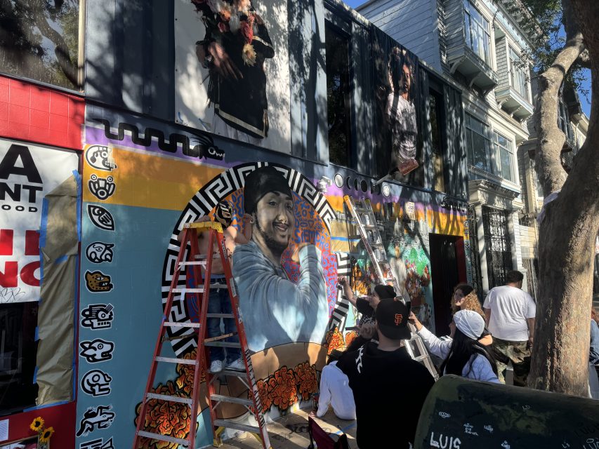 Friends and family paint a mural for Luis Arguello-Inglis at the intersection of 24th and Folsom streets on Tuesday May 16, 2024. Photo by Oscar Palma