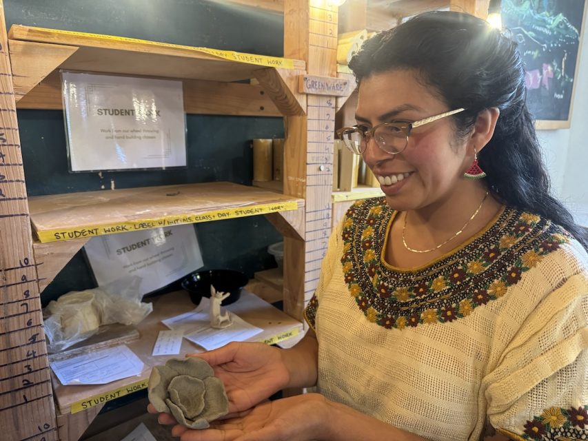 Kelly Ortega poses with one of the pieces created with foraged clay from one of their outdoors classes on Thursday July 18, 2024. Photo by Oscar Palma.