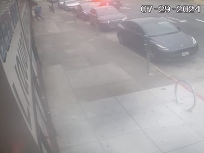 A surveillance camera captures a city street scene showing parked cars, including a dark-colored vehicle with its brake lights on. The date stamp reads "07-29-2024.