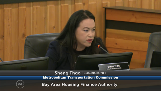 Sheng Thao, a commissioner at the Metropolitan Transportation Commission, is speaking into a microphone during a Bay Area Housing Finance Authority meeting.