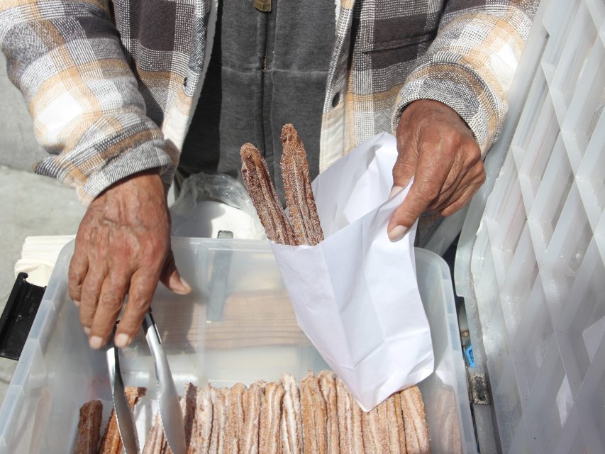 Raymundo Jimenez packs three of his homemade churros at the intersection of 21st and Mission streets on Friday Aug. 9, 2024. Photo by Oscar Palma.