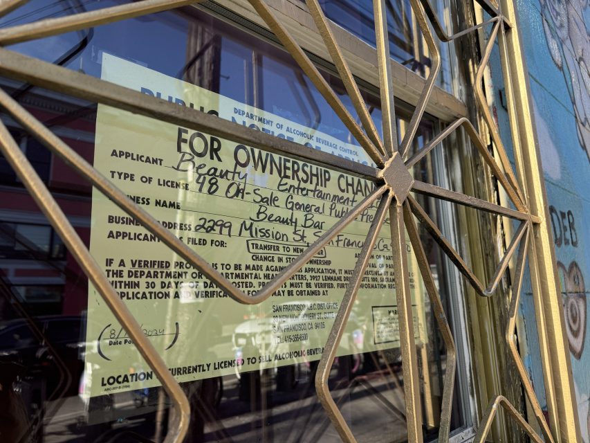 A notice of ownership change for Beauty Bar is displayed on a window. The notice lists the address as 2299 Mission St. and details a license application for serving alcohol.