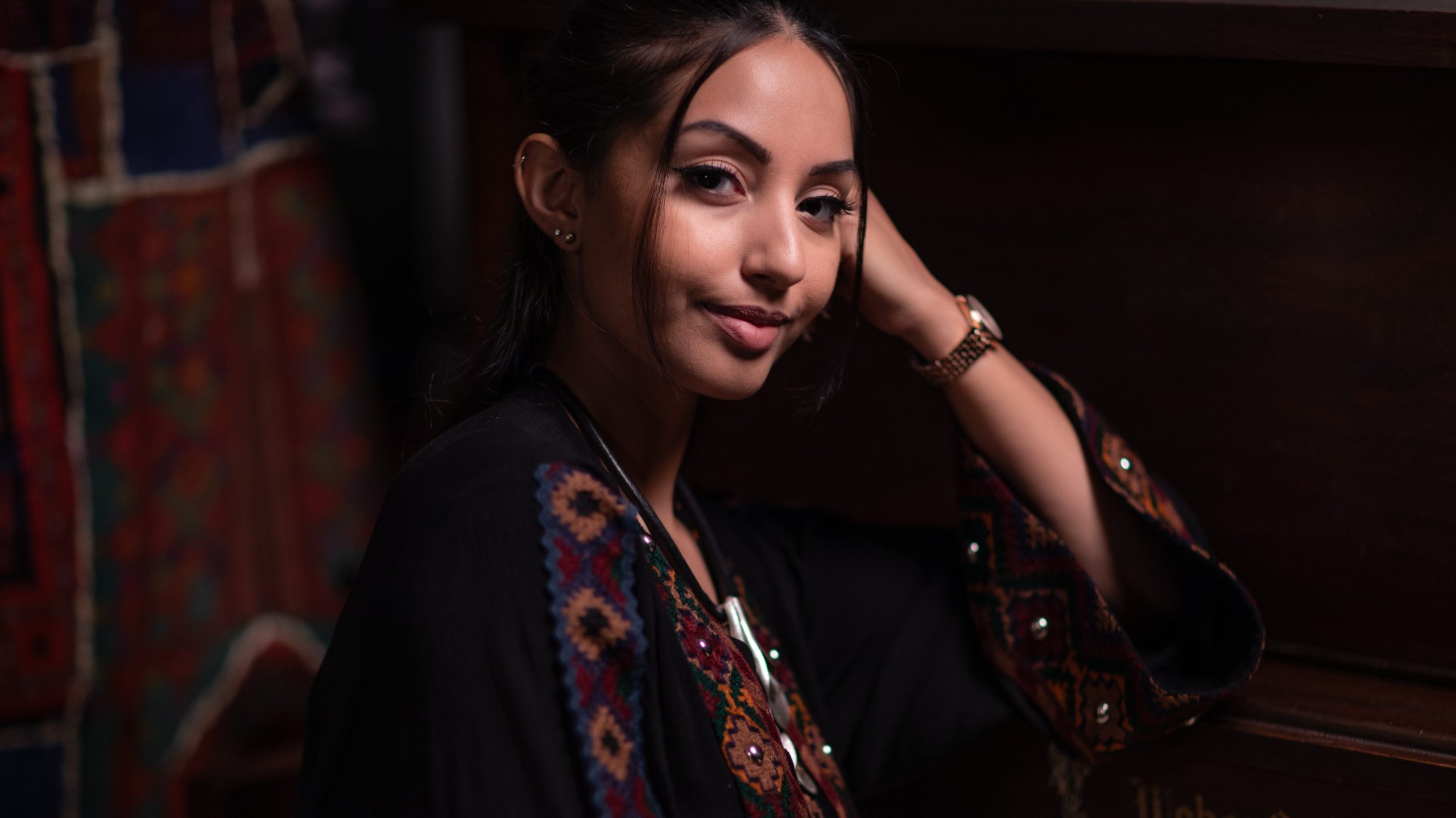 a young Afghan-American woman poses smiling in a portrait