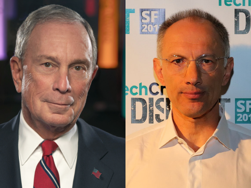 Two men are pictured: the one on the left wearing a suit and red tie, and the one on the right in a white shirt standing in front of a backdrop with logos.